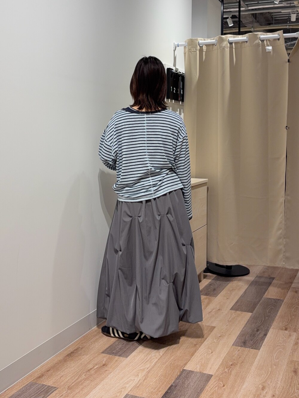 ブルー系のTシャツ/カットソー、グレー系のスカートを着用したレディースの春コーディネートの3枚目の写真