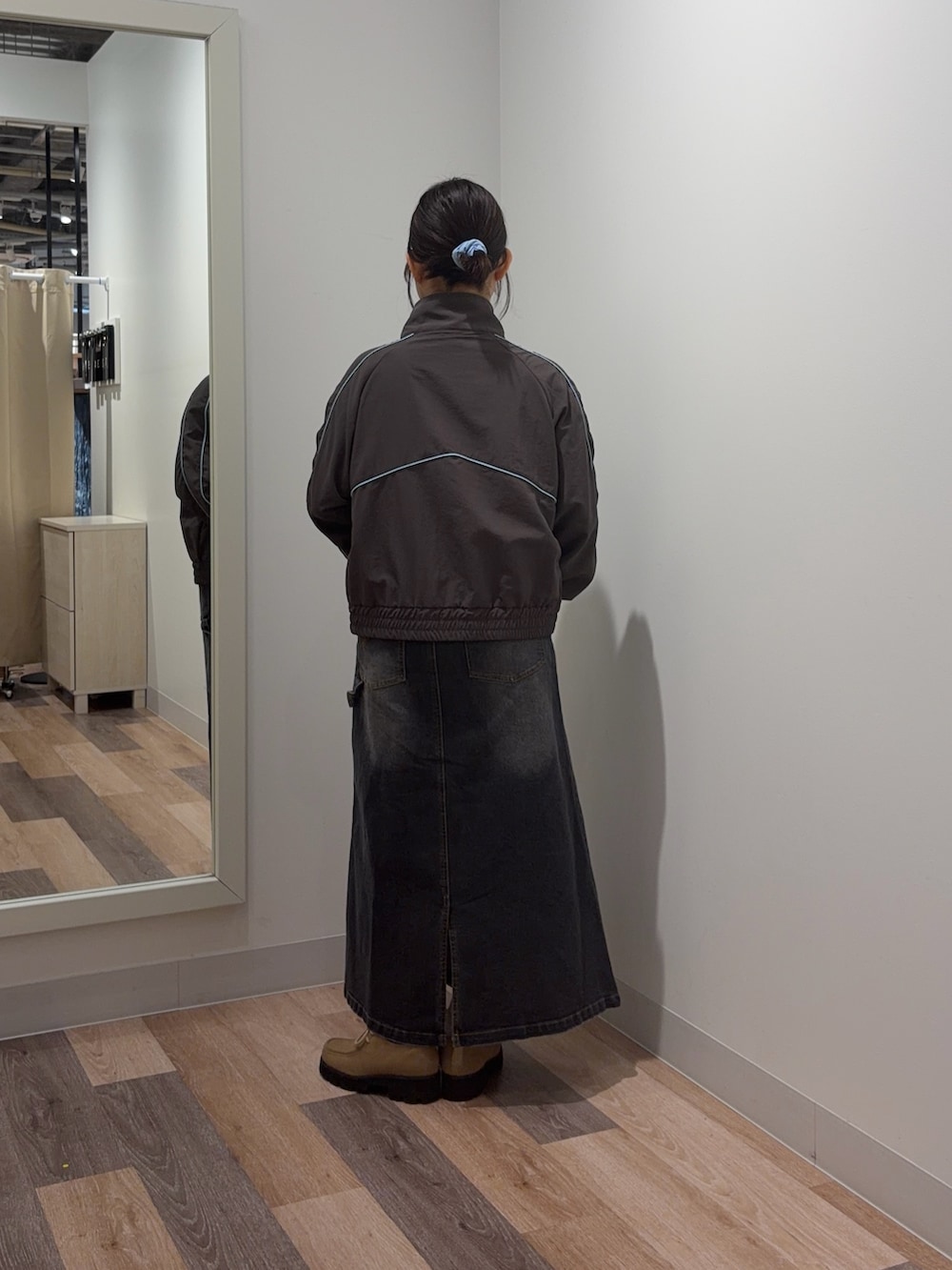 グレー系のブルゾン、ブラック系のスカートを着用したレディースの春コーディネートの3枚目の写真