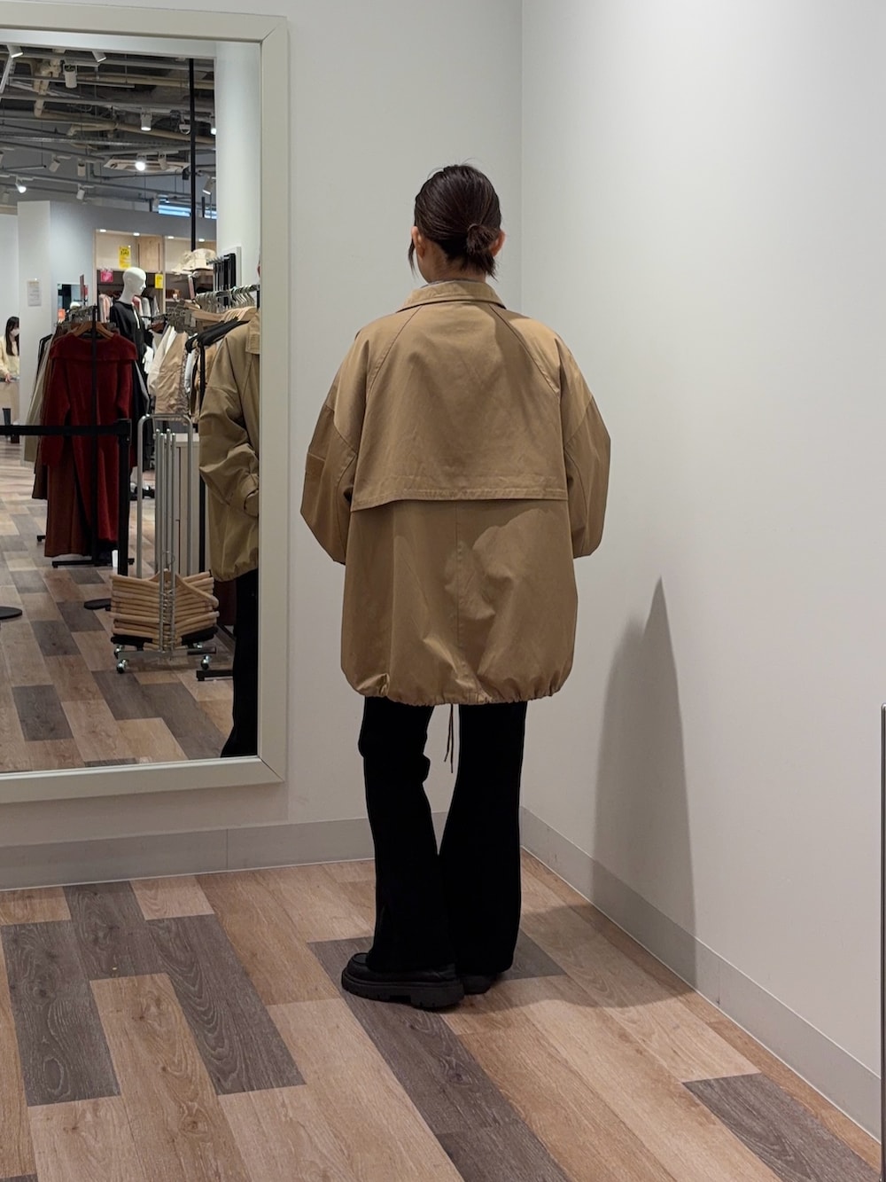 ブラック系のブルゾン、ホワイト系のパーカーを着用したレディースの冬コーディネートの3枚目の写真