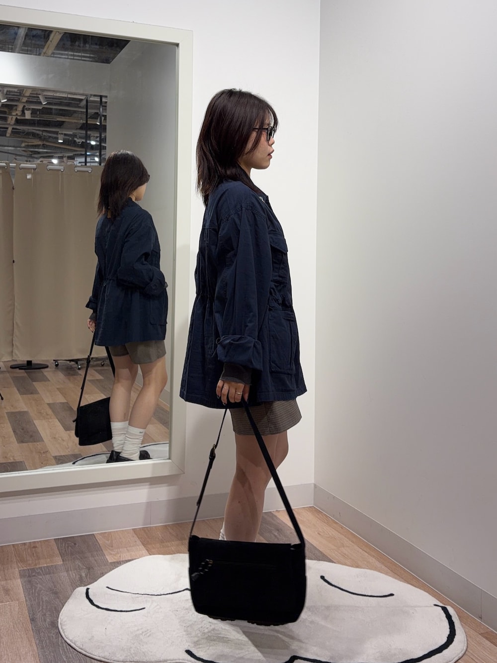 グレー系のTシャツ/カットソー、ブルー系のミリタリージャケットを着用したレディースの秋コーディネートの2枚目の写真
