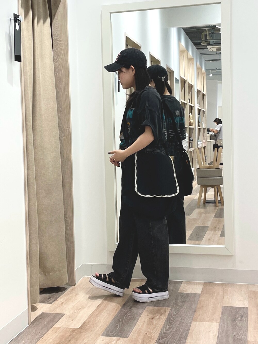 ブラック系のデニムパンツ、グレー系のTシャツ/カットソー、ブラック系のショルダーバッグを着用したレディースの夏コーディネートの2枚目の写真