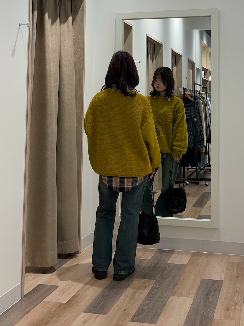 イエロー系のニット/セーター、ブルー系のデニムパンツを着用したレディースの秋コーディネートの3枚目の写真