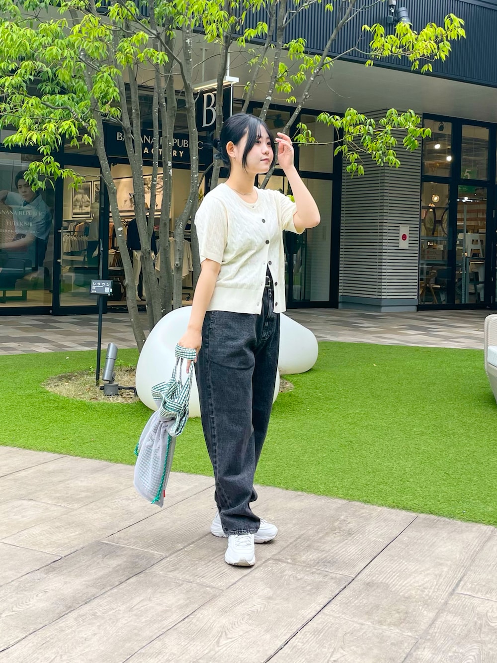 ホワイト系のカーディガン/ボレロ、ブラック系のデニムパンツ、グリーン系のトートバッグを着用したレディースの夏コーディネートの2枚目の写真