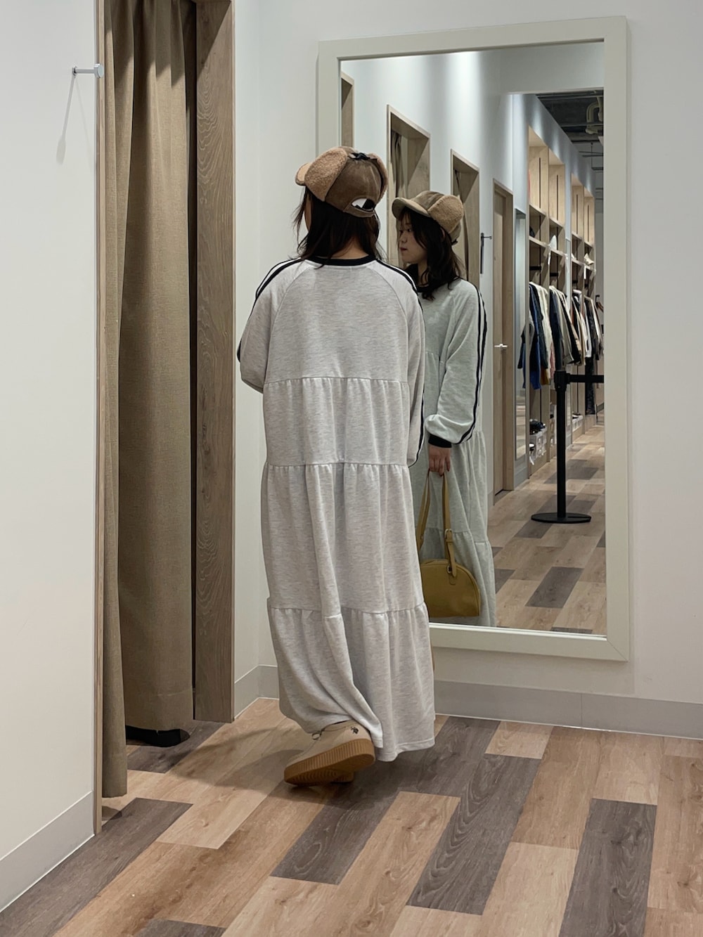 グレー系のワンピース、ブラウン系のボストンバッグを着用したレディースの秋コーディネートの3枚目の写真