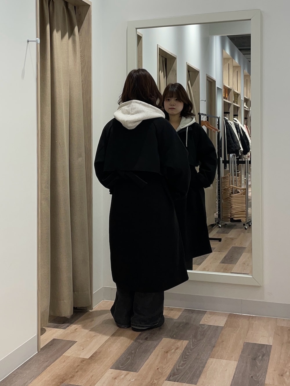 グレー系のパーカー、ブラック系のデニムパンツ、グレー系のその他アウターを着用したレディースの冬コーディネートの3枚目の写真