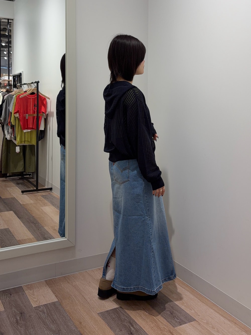 ブルー系のスカート、ブルー系のパーカー、ホワイト系のキャミソールを着用したレディースの春コーディネートの2枚目の写真