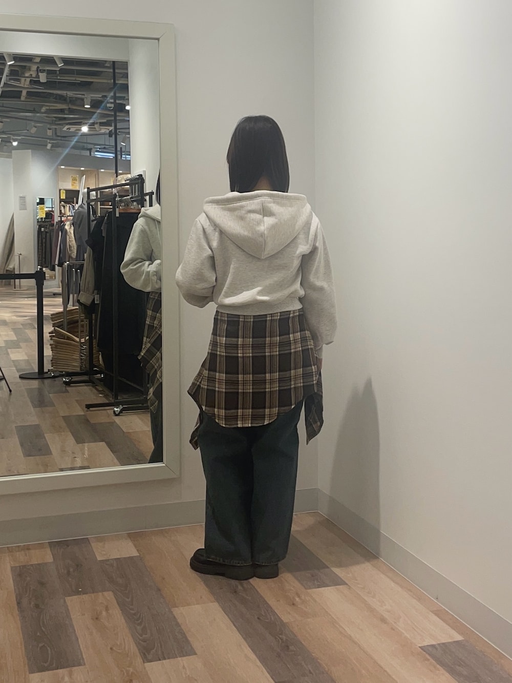 グレー系のパーカー、ブルー系のデニムパンツを着用したレディースの冬コーディネートの3枚目の写真