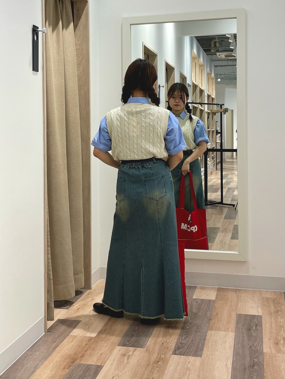 ブルー系のシャツ/ブラウス、ブルー系のスカート、レッド系のトートバッグを着用したレディースの夏コーディネートの3枚目の写真