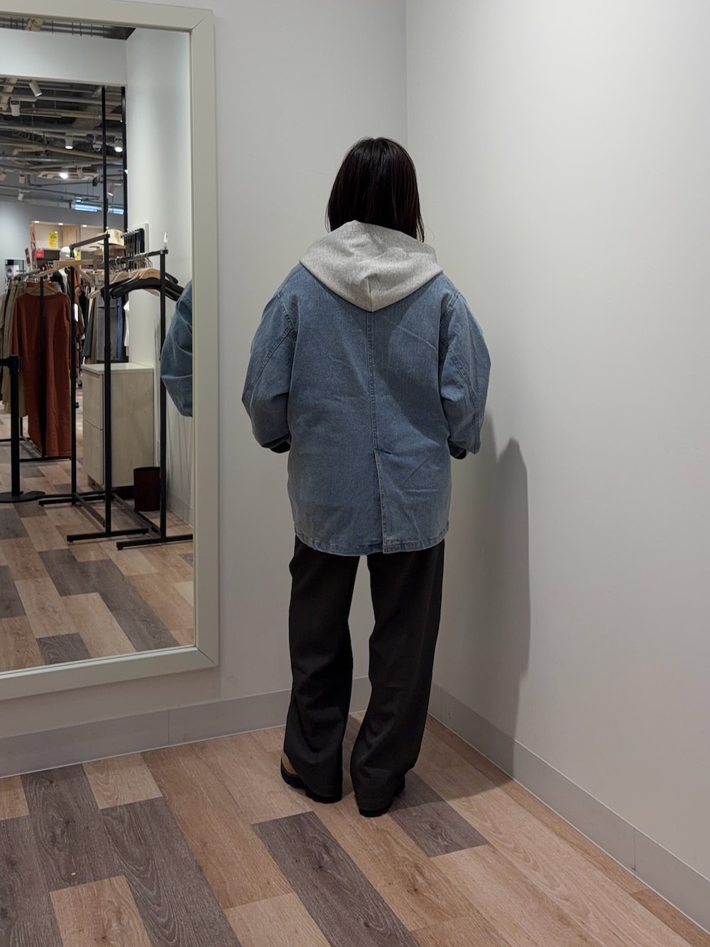 グレー系のパーカー、ブルー系のテーラードジャケット、ブラック系のその他パンツを着用したレディースの春コーディネートの3枚目の写真