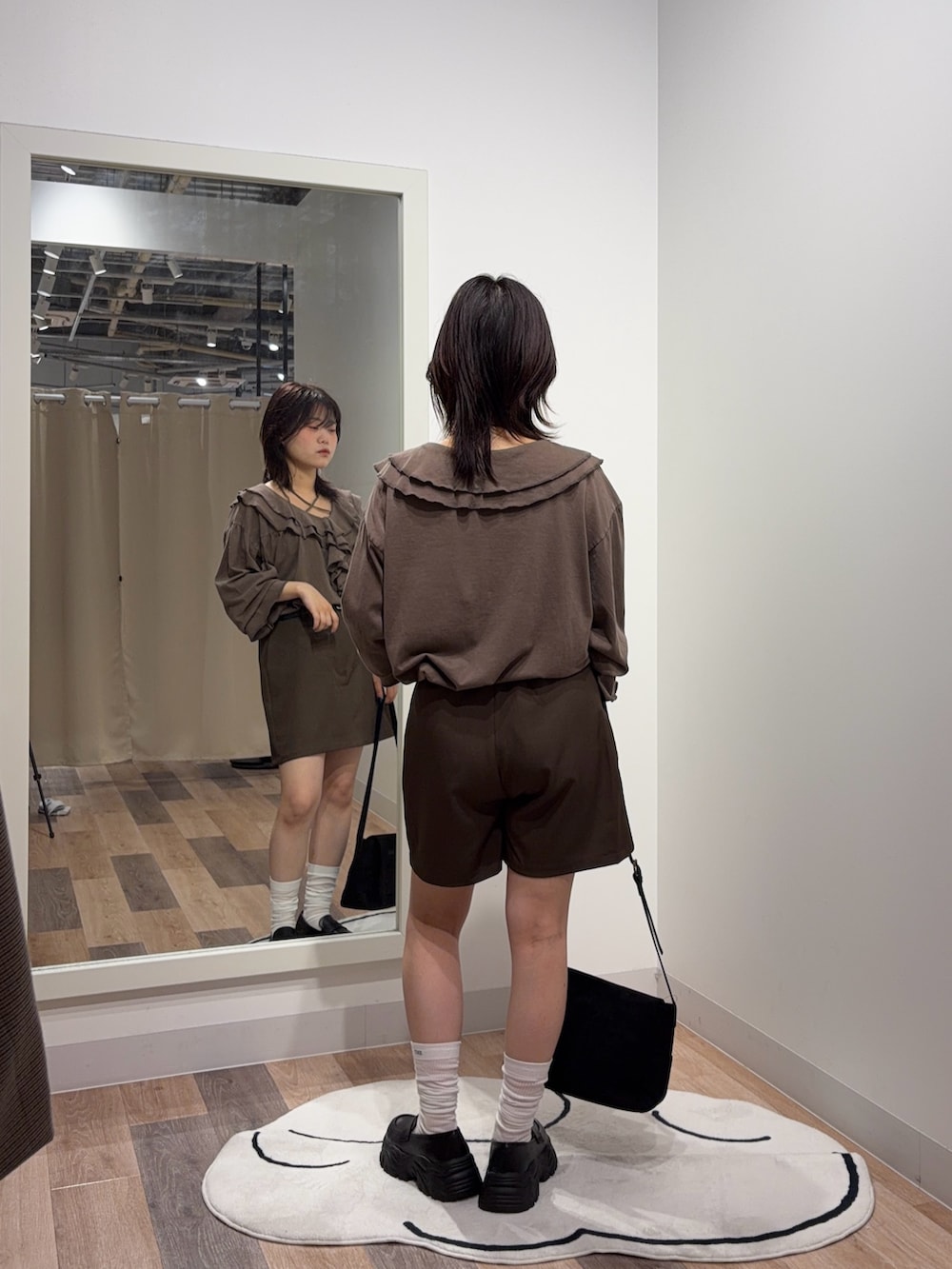 ブラウン系のシャツ/ブラウス、ブラウン系のショルダーバッグ、ブラック系のローファーを着用したレディースの秋コーディネートの3枚目の写真