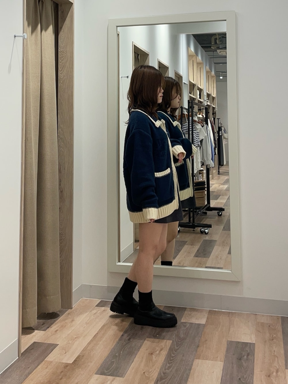 ブルー系のカーディガン/ボレロ、ブラック系のブーツを着用したレディースの秋コーディネートの2枚目の写真