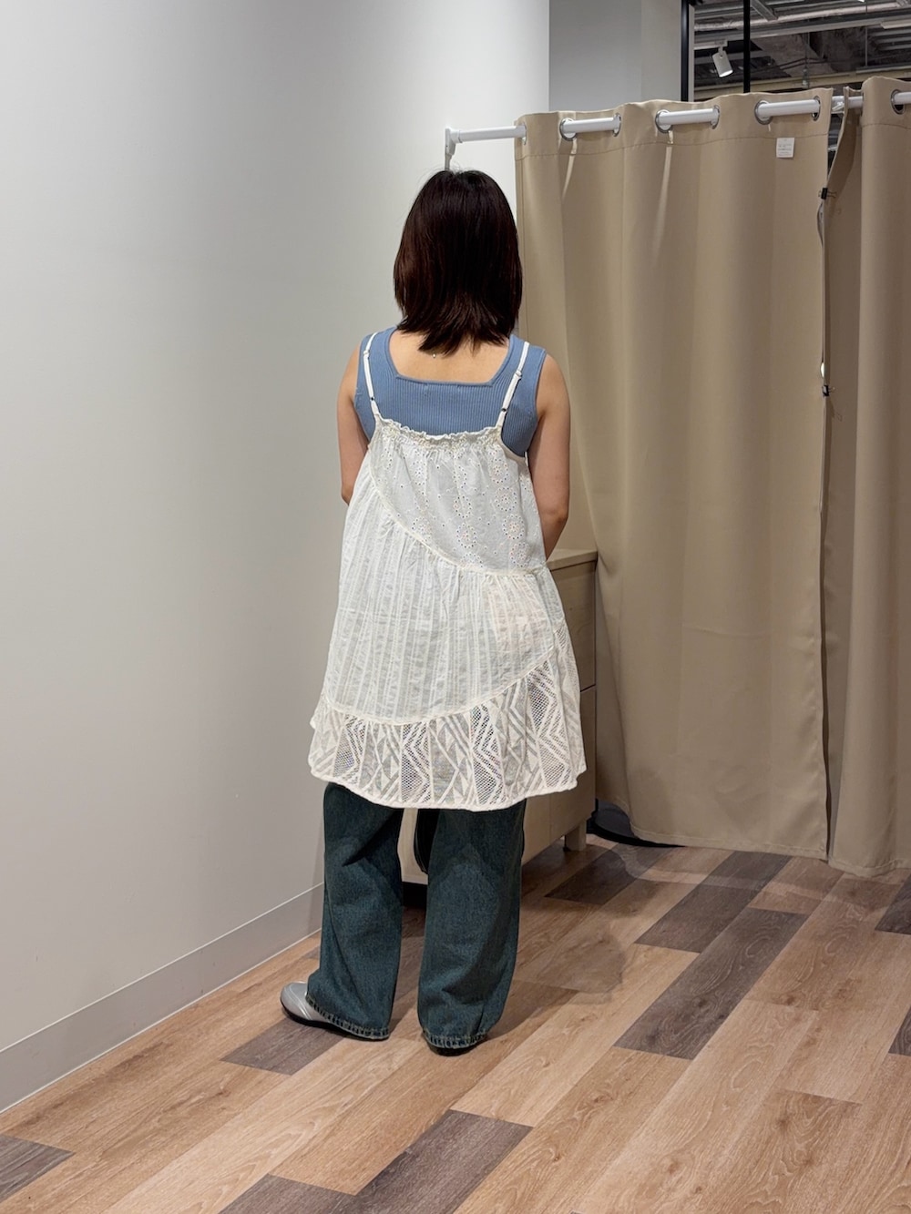 ブルー系のキャミソール、ホワイト系のスカート、ブルー系のデニムパンツを着用したレディースの春コーディネートの3枚目の写真