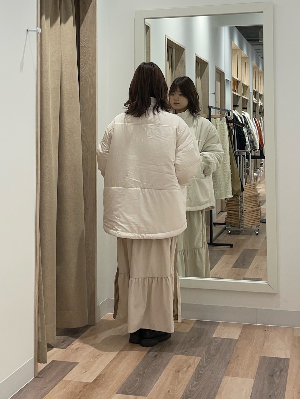 ブラック系のブルゾン、ホワイト系のスカート、ホワイト系のニット/セーターを着用したレディースの冬コーディネートの3枚目の写真