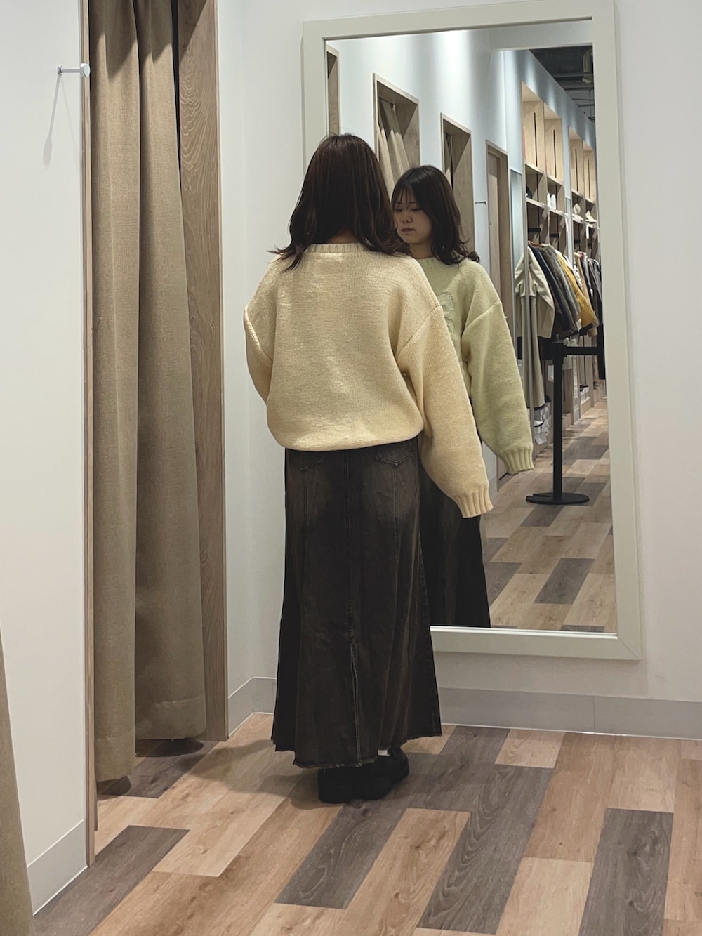 ブルー系のニット/セーター、ブルー系のスカートを着用したレディースの秋コーディネートの3枚目の写真