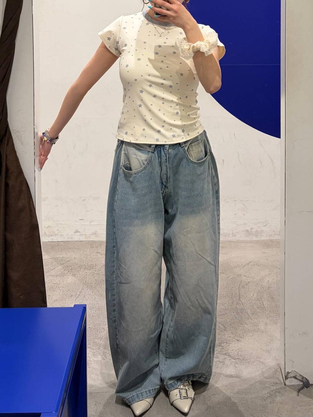 ブルー系のデニムパンツ、ホワイト系のパンプス、ホワイト系のTシャツ/カットソーを着用したレディースの夏コーディネートの2枚目の写真