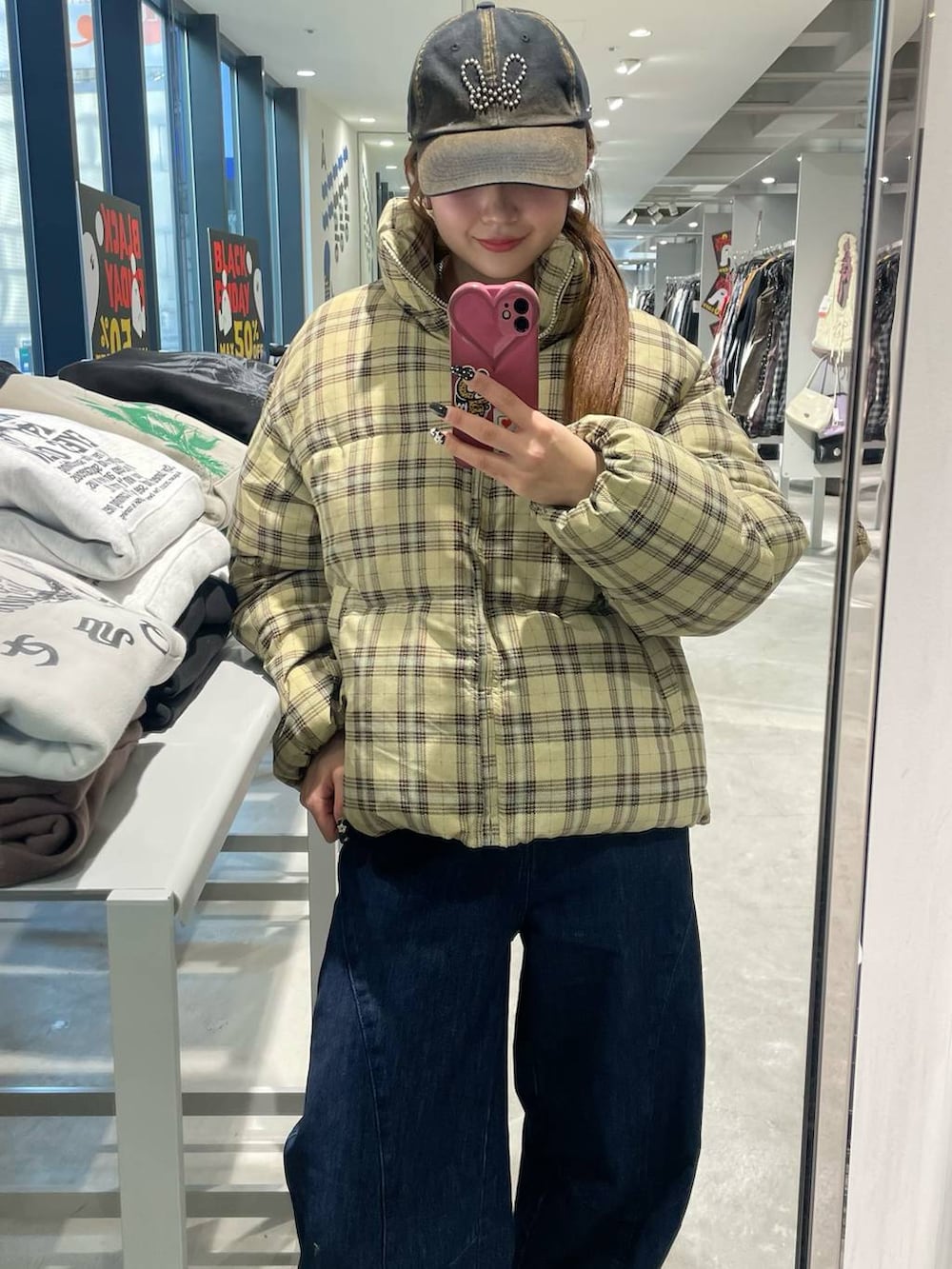 ベージュ系のダウンジャケット/コート、ベージュ系のスリッポン、ブルー系のデニムパンツを着用したレディースの秋コーディネートの2枚目の写真