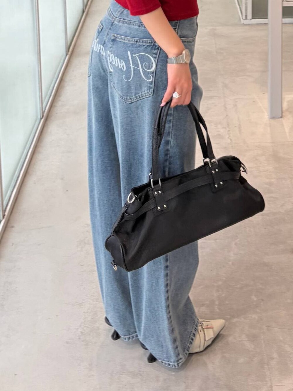 ブルー系のデニムパンツ、ホワイト系のパンプス、レッド系のTシャツ/カットソーを着用したレディースの夏コーディネートの4枚目の写真