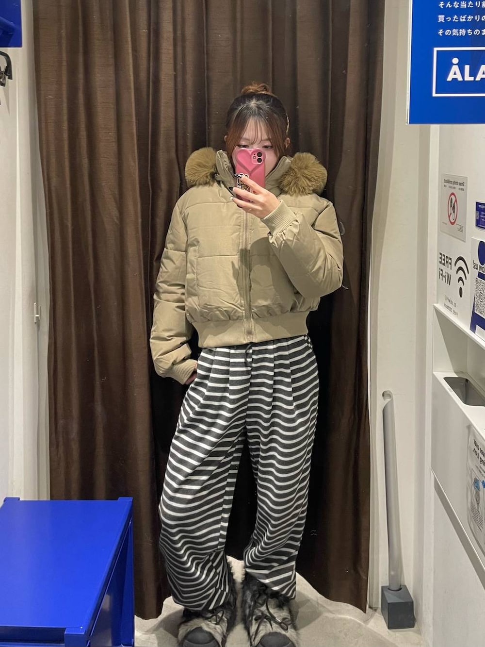 グレー系のブーツ、ベージュ系のダウンジャケット/コート、ブラック系のスウェットパンツを着用したレディースの冬コーディネートの2枚目の写真