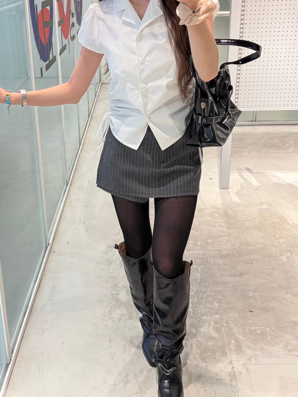 グレー系のその他パンツ、ブラック系のブーツ、ホワイト系のシャツ/ブラウスを着用したレディースの春コーディネートの2枚目の写真