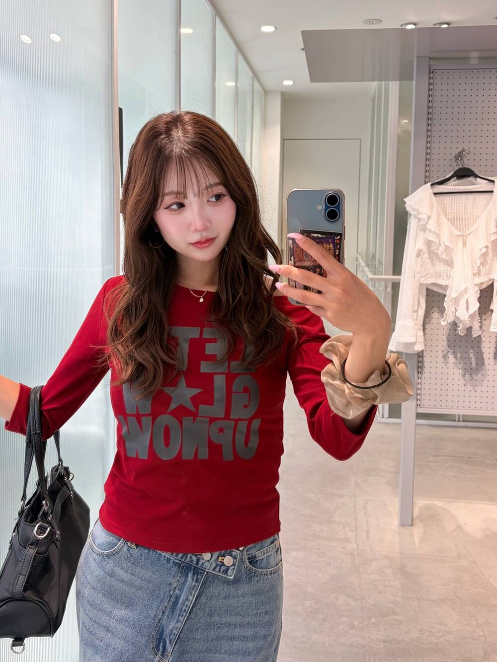 ブルー系のデニムパンツ、ホワイト系のパンプス、レッド系のTシャツ/カットソーを着用したレディースの夏コーディネートの2枚目の写真