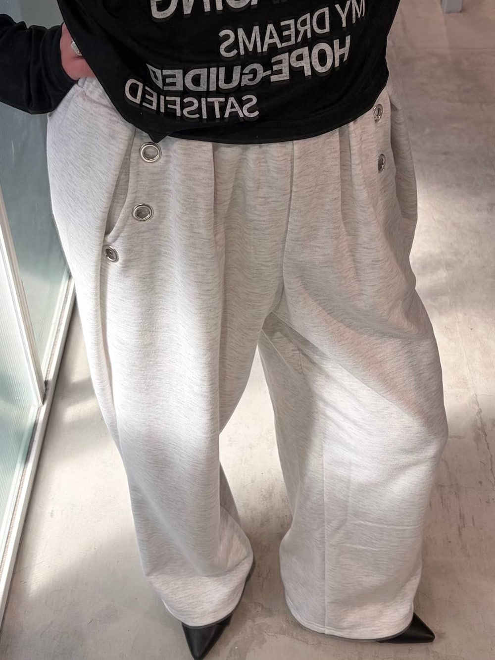 ブラック系のパンプス、グレー系のスウェットパンツ、ブラック系のTシャツ/カットソーを着用したレディースの春コーディネートの3枚目の写真