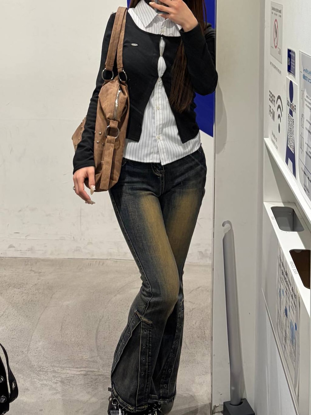 ブラック系のパンプス、ブルー系のデニムパンツ、ブラック系のカーディガン/ボレロを着用したレディースの冬コーディネートの3枚目の写真