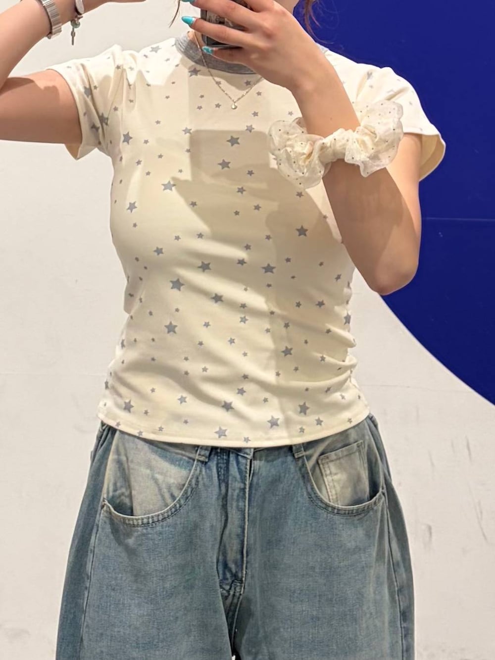 ブルー系のデニムパンツ、ホワイト系のパンプス、ホワイト系のTシャツ/カットソーを着用したレディースの夏コーディネートの4枚目の写真