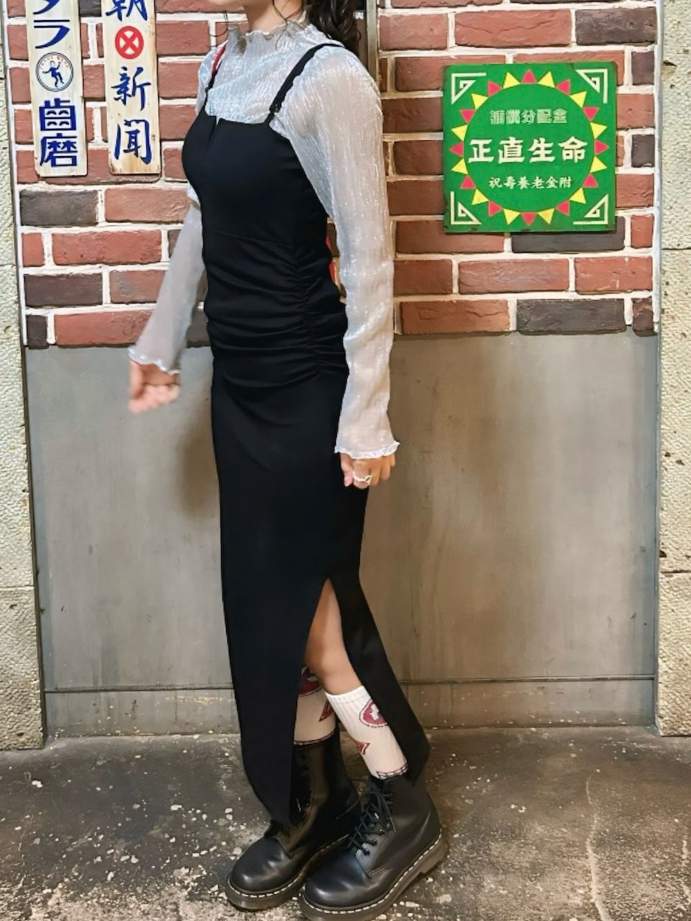 ブラック系のワンピース、ブラック系のブーツを着用したレディースの春コーディネートの2枚目の写真