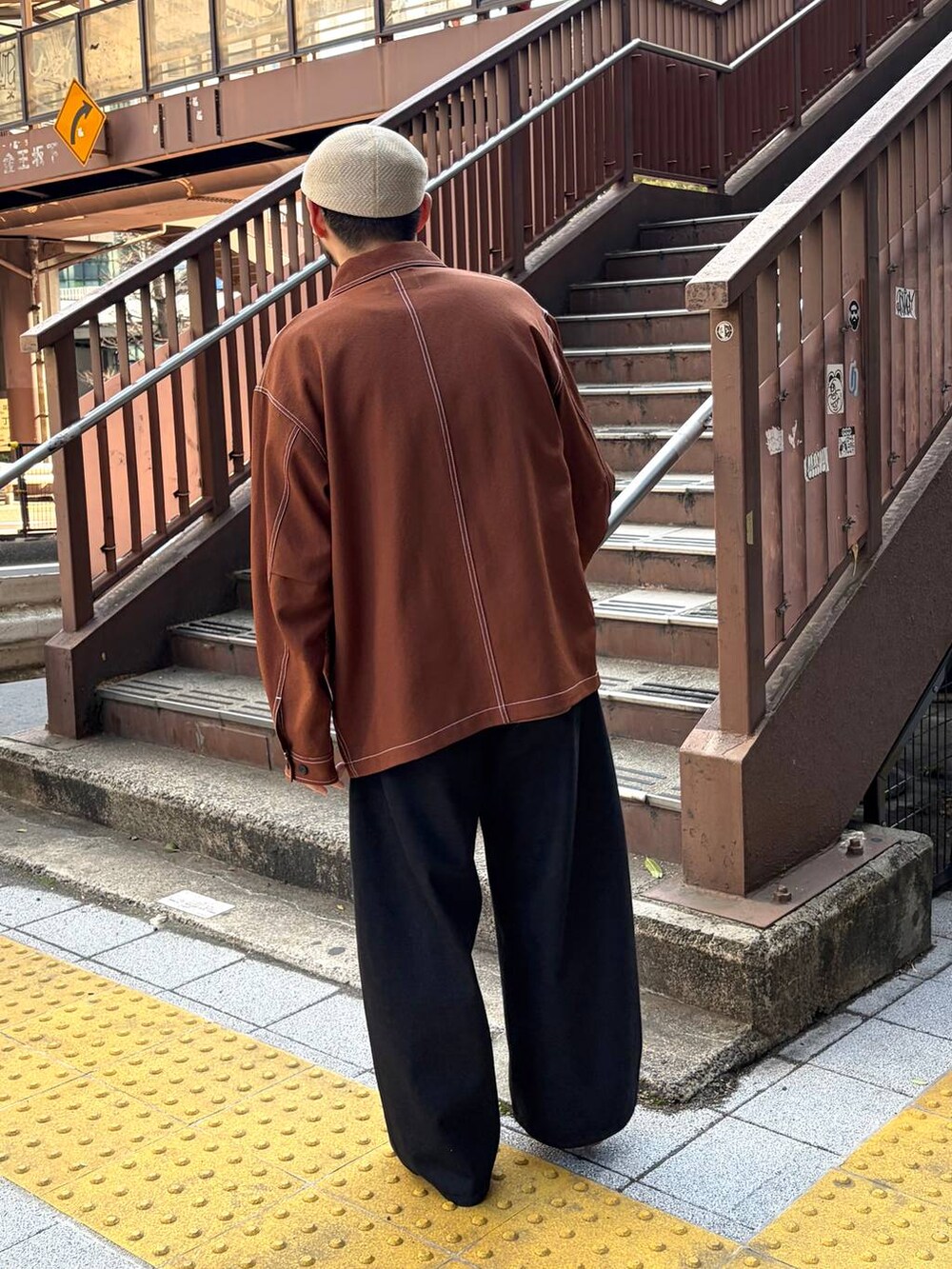 ブラウン系のカバーオール、ブラウン系のTシャツ/カットソー、ブラック系のデニムパンツを着用したメンズの春コーディネートの4枚目の写真