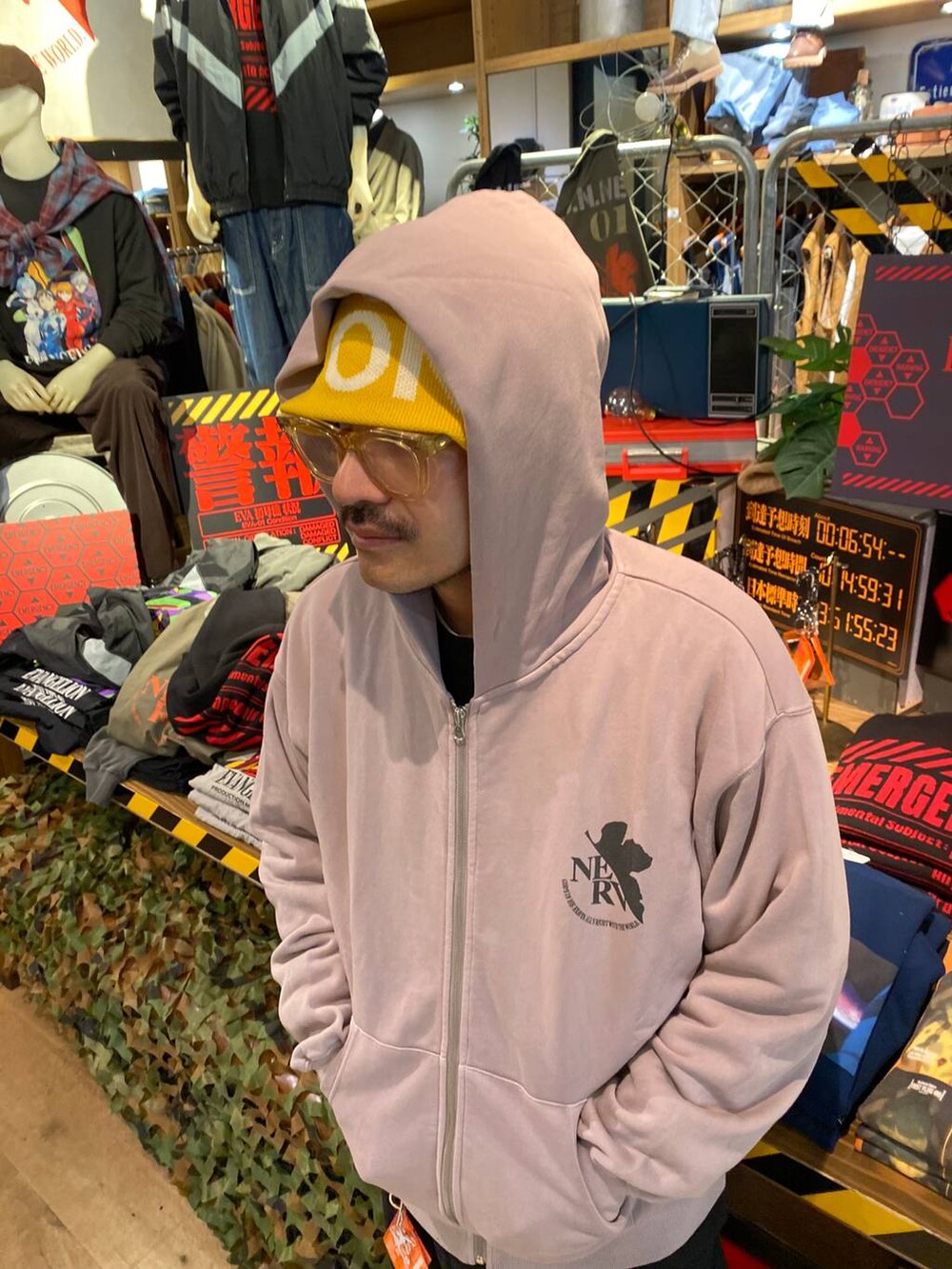 グレー系のパーカー、レッド系のカードケース、イエロー系のニットキャップ/ビーニーを着用したメンズの秋コーディネートの4枚目の写真