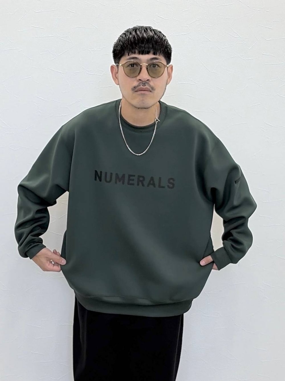 グリーン系のTシャツ/カットソー、ブラック系のその他パンツ、グリーン系のサングラスを着用したメンズの秋コーディネートの5枚目の写真