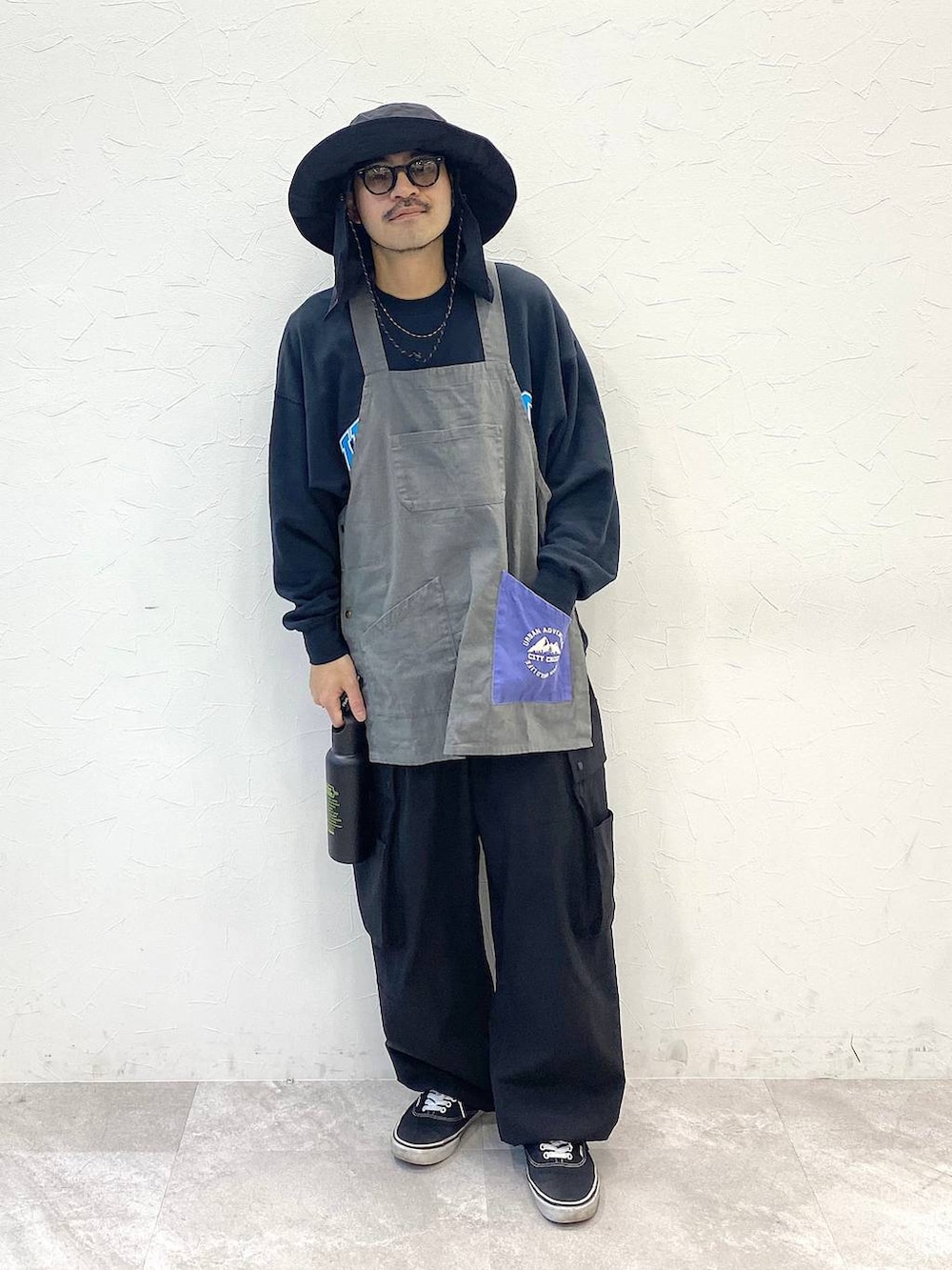 ブラック系のその他パンツ、グレー系のエプロン、ブラック系のハットを着用したメンズの春コーディネートの5枚目の写真
