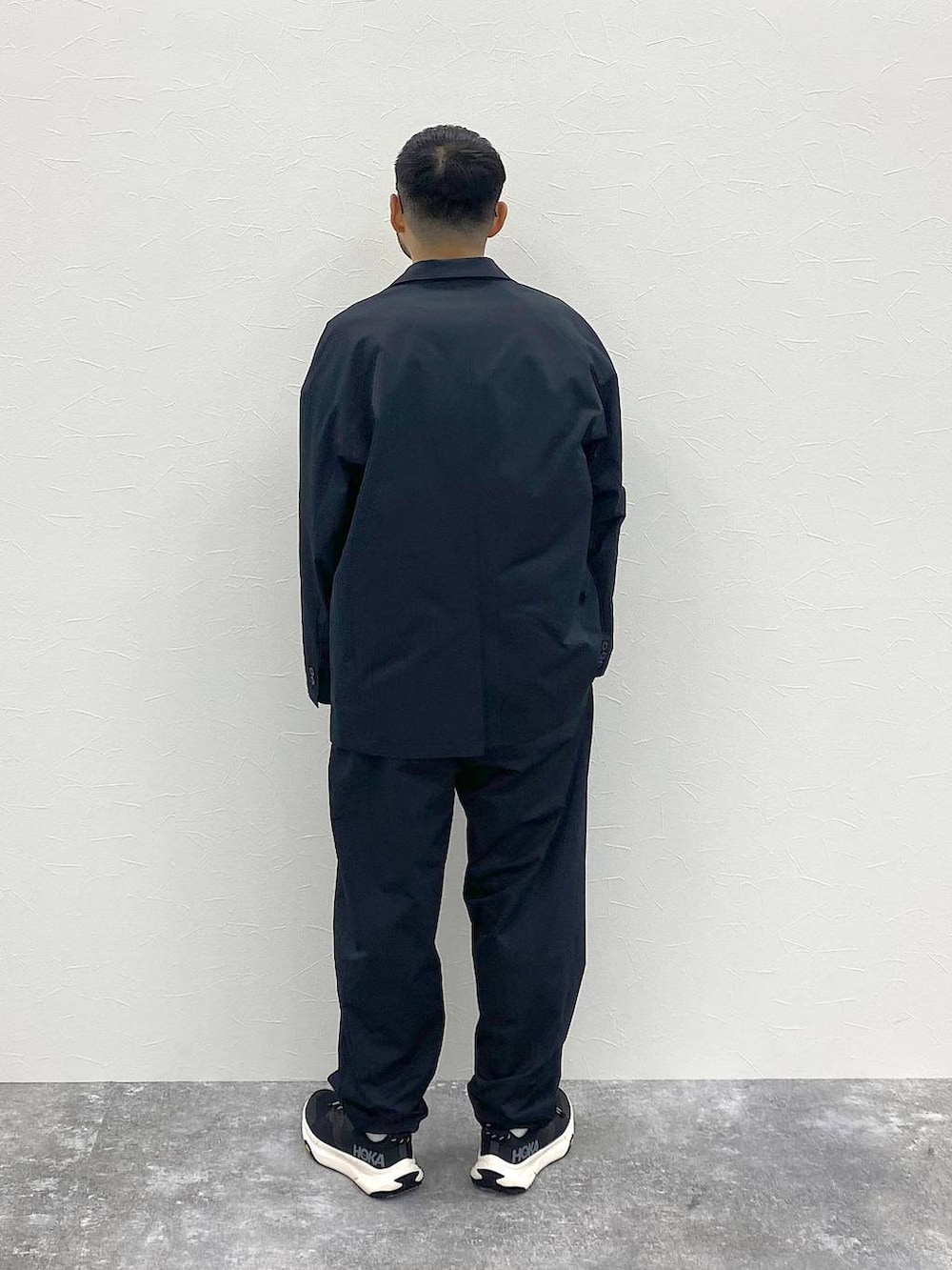 ブラック系のテーラードジャケット、ホワイト系のTシャツ/カットソー、ブラック系のスラックスを着用したメンズの夏コーディネートの4枚目の写真
