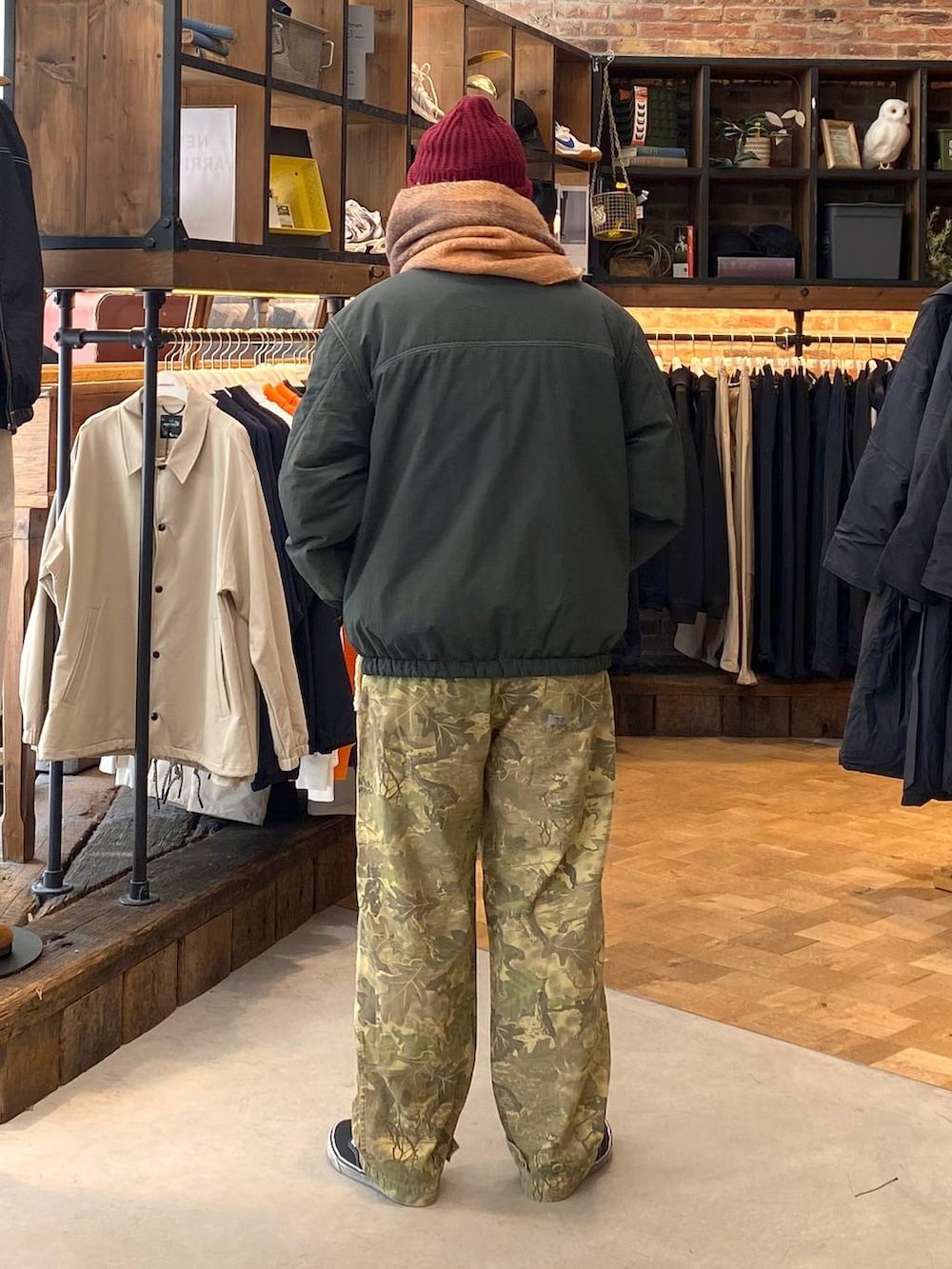 グリーン系のブルゾン、ベージュ系のその他パンツ、イエロー系のマフラーを着用したメンズの秋コーディネートの3枚目の写真