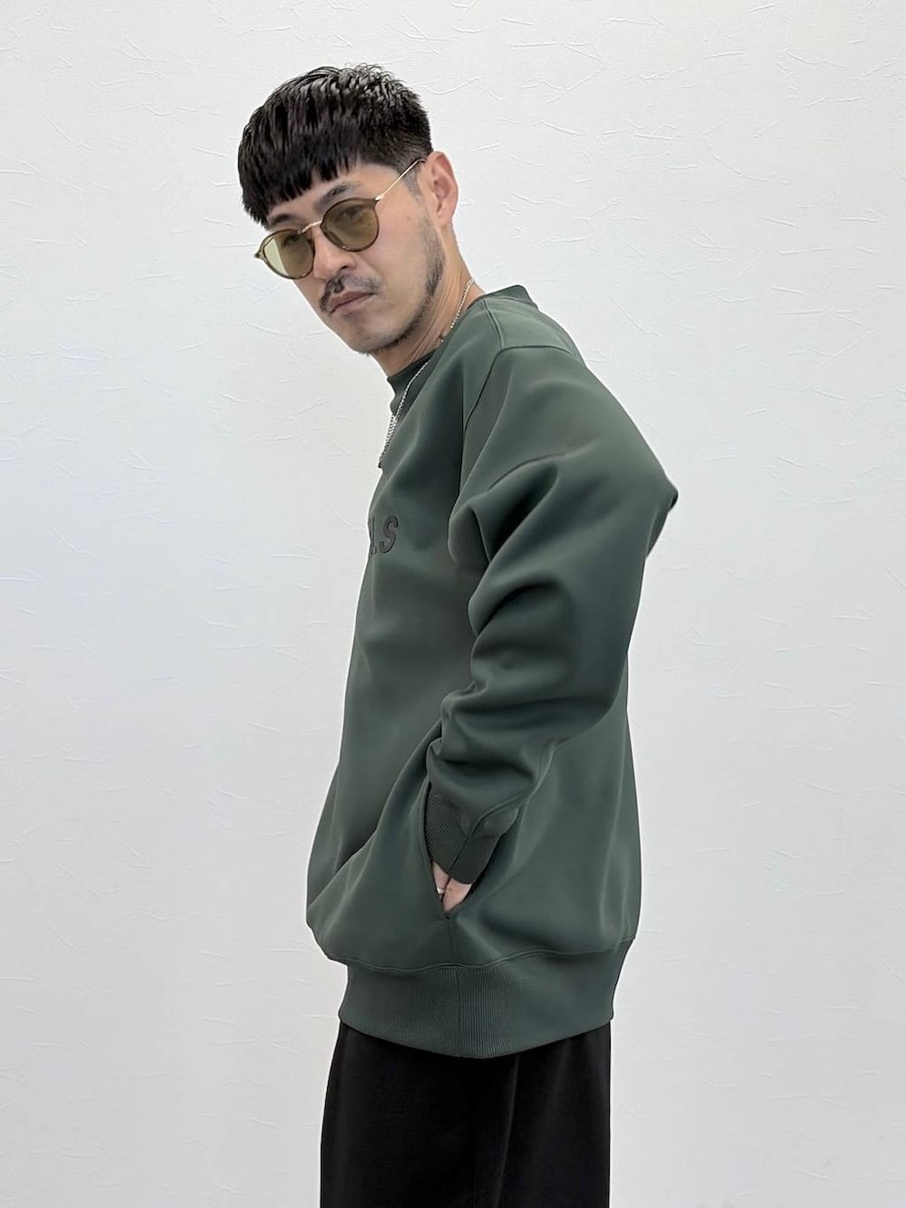 グリーン系のTシャツ/カットソー、ブラック系のその他パンツ、グリーン系のサングラスを着用したメンズの秋コーディネートの3枚目の写真