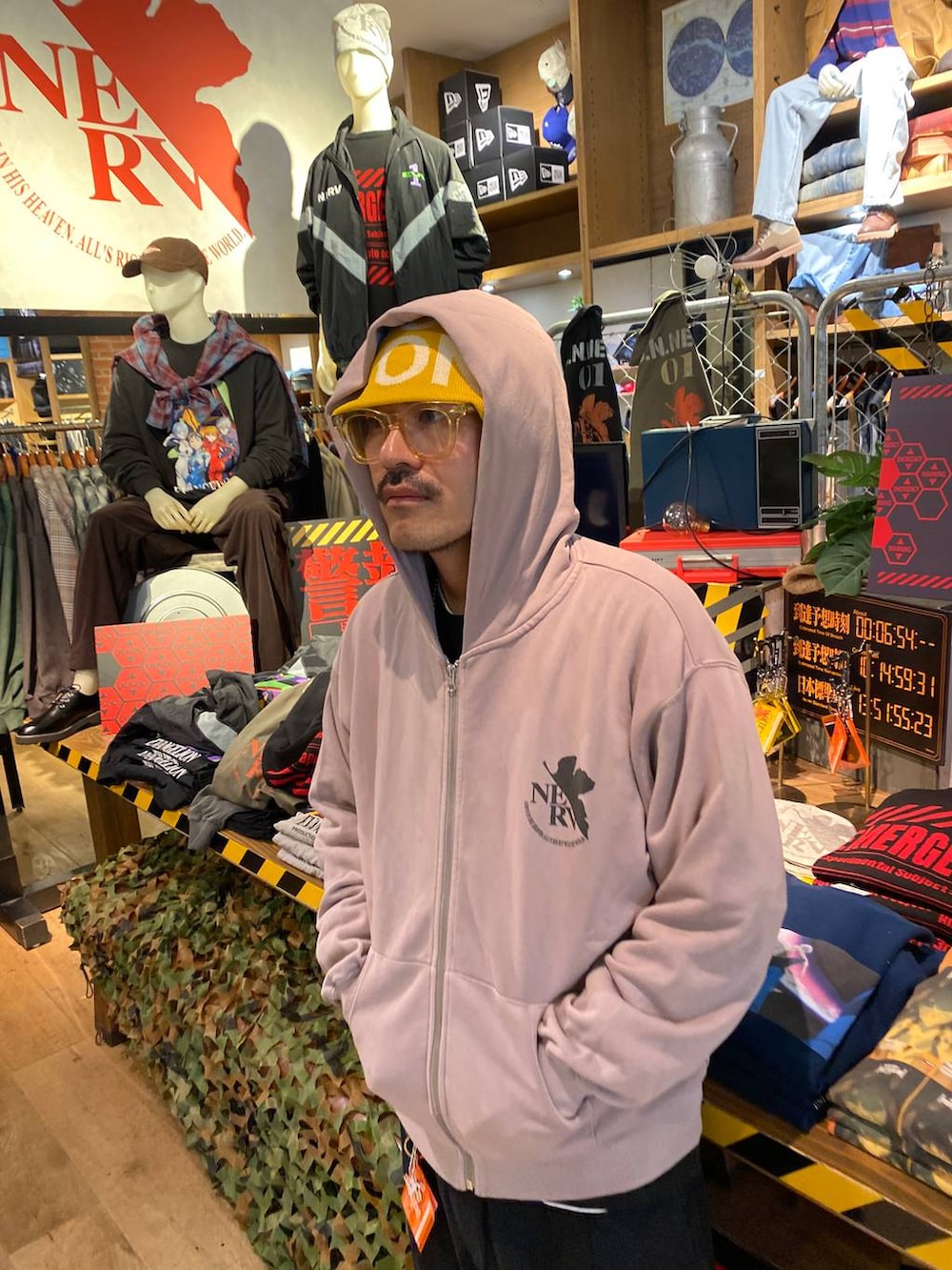 グレー系のパーカー、レッド系のカードケース、イエロー系のニットキャップ/ビーニーを着用したメンズの秋コーディネートの3枚目の写真