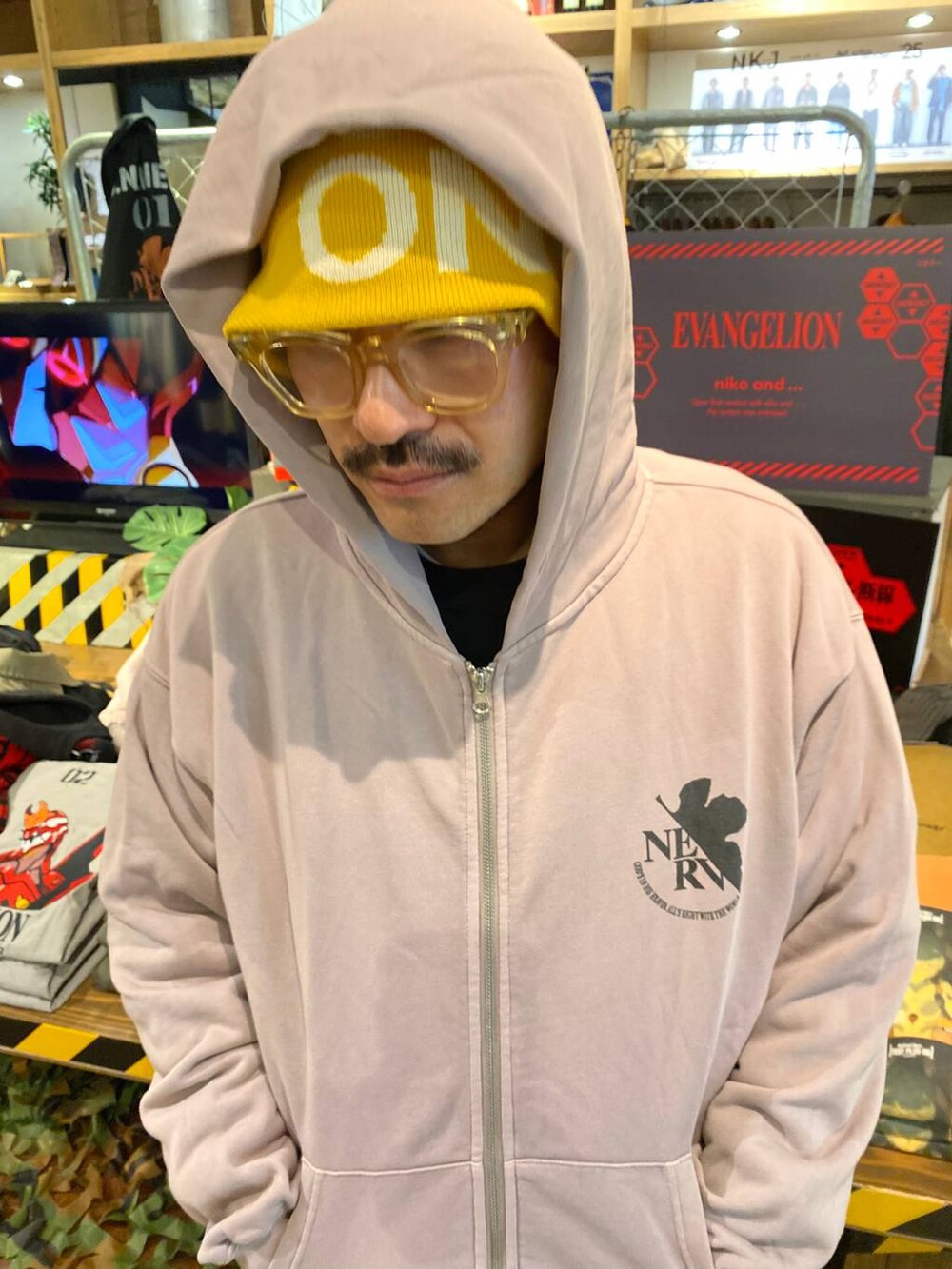 グレー系のパーカー、レッド系のカードケース、イエロー系のニットキャップ/ビーニーを着用したメンズの秋コーディネートの2枚目の写真