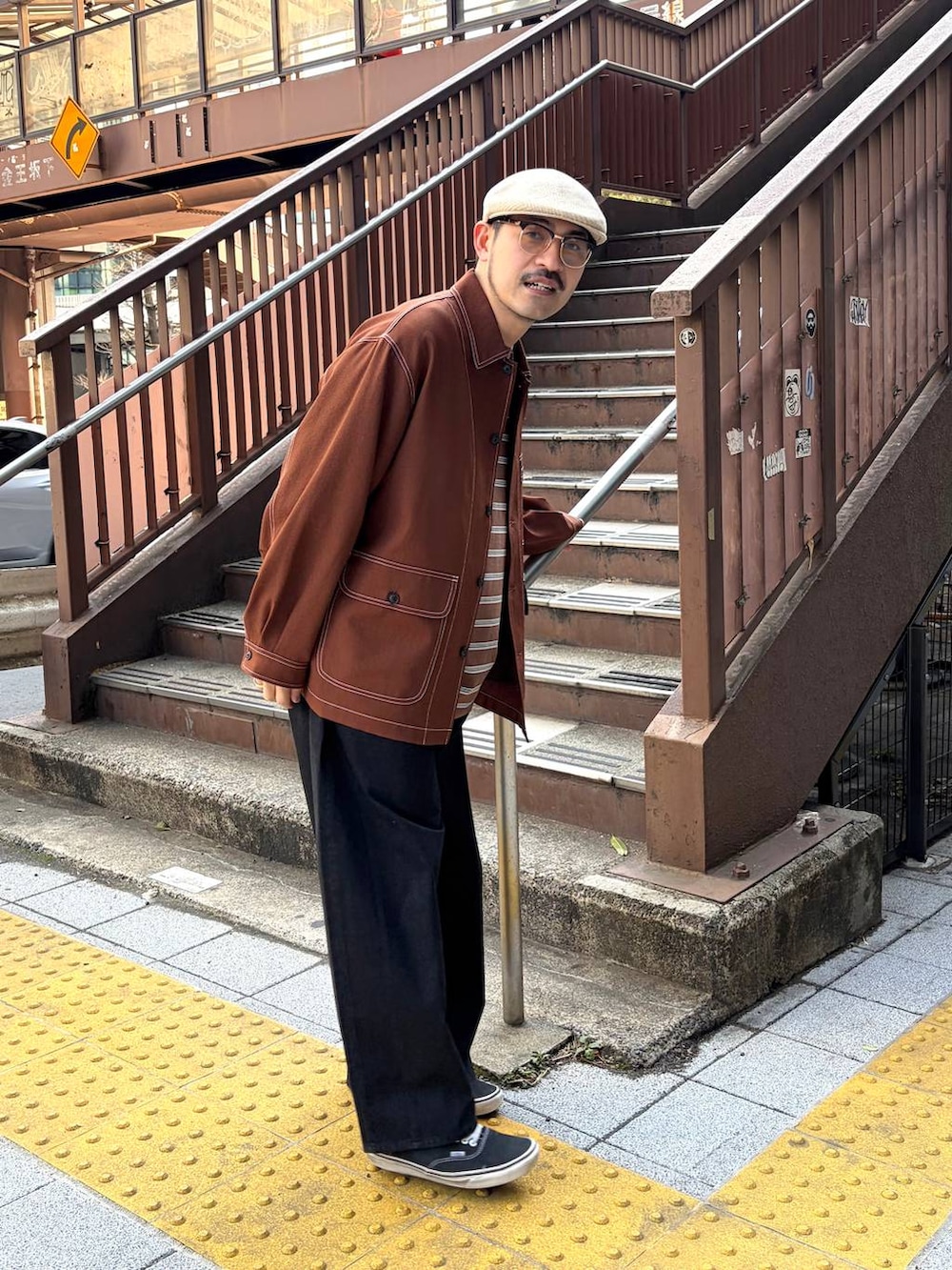 ブラウン系のカバーオール、ブラウン系のTシャツ/カットソー、ブラック系のデニムパンツを着用したメンズの春コーディネートの3枚目の写真