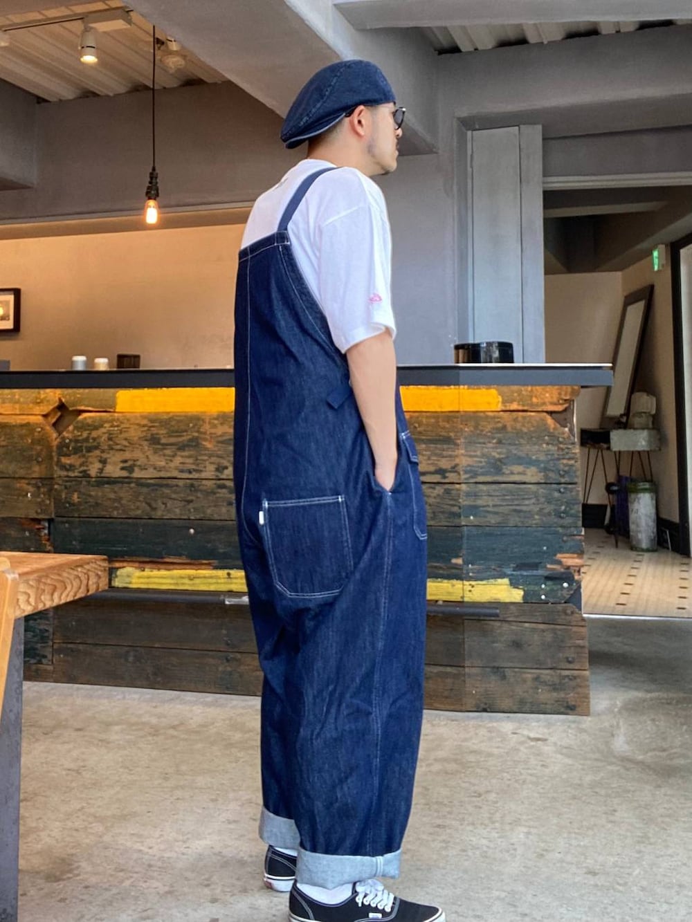 ブルー系のサロペット/オーバーオール、ホワイト系のTシャツ/カットソー、ブラック系のサングラスを着用したメンズの夏コーディネートの4枚目の写真