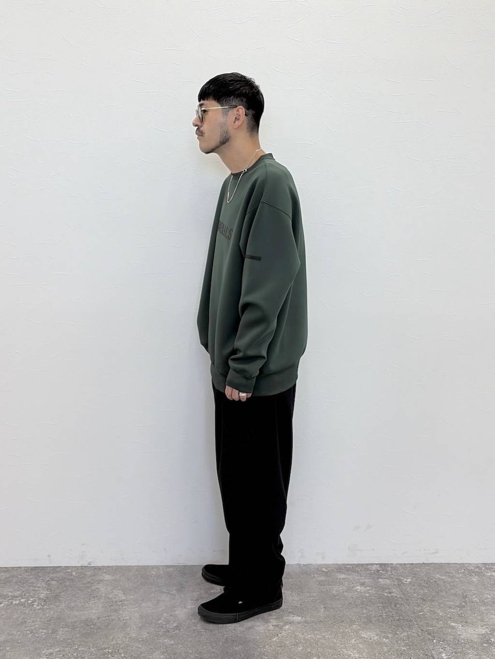 グリーン系のTシャツ/カットソー、ブラック系のその他パンツ、グリーン系のサングラスを着用したメンズの秋コーディネートの6枚目の写真