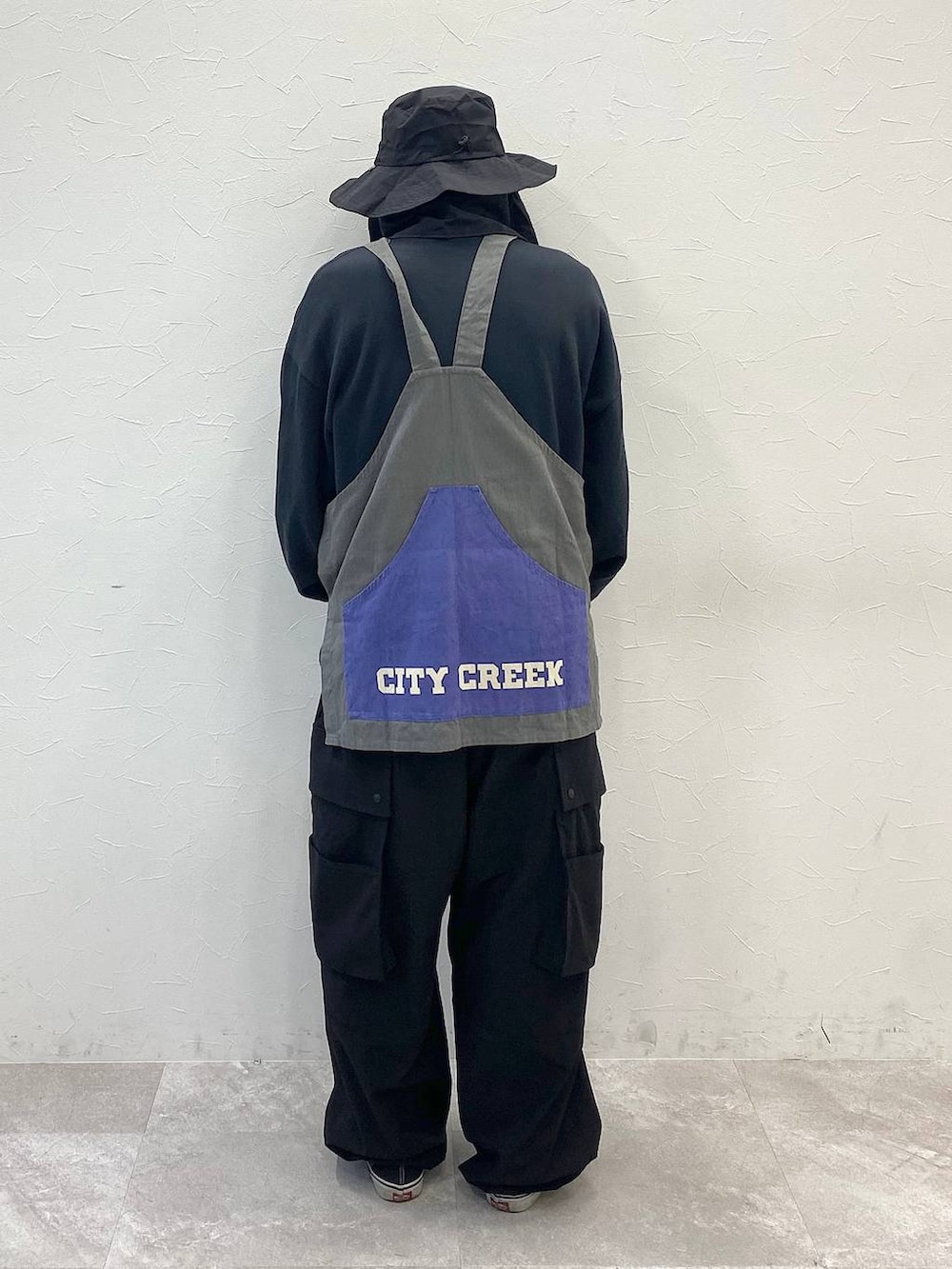 ブラック系のその他パンツ、グレー系のエプロン、ブラック系のハットを着用したメンズの春コーディネートの3枚目の写真