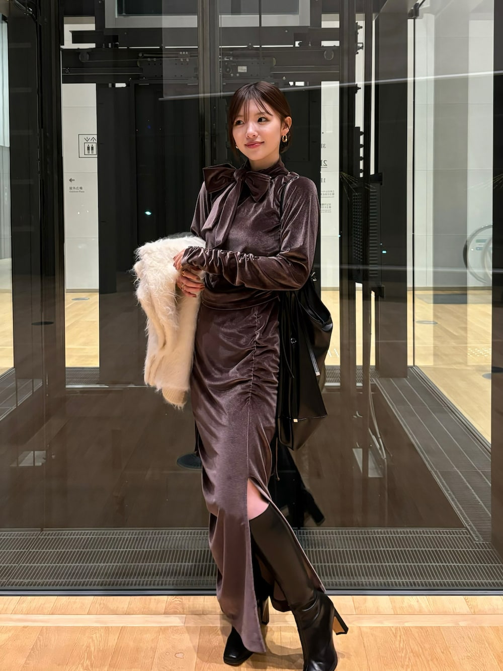 ブラウン系のTシャツ/カットソー、ベージュ系のカーディガン/ボレロ、ブラウン系のスカートを着用したレディースの冬コーディネートの3枚目の写真