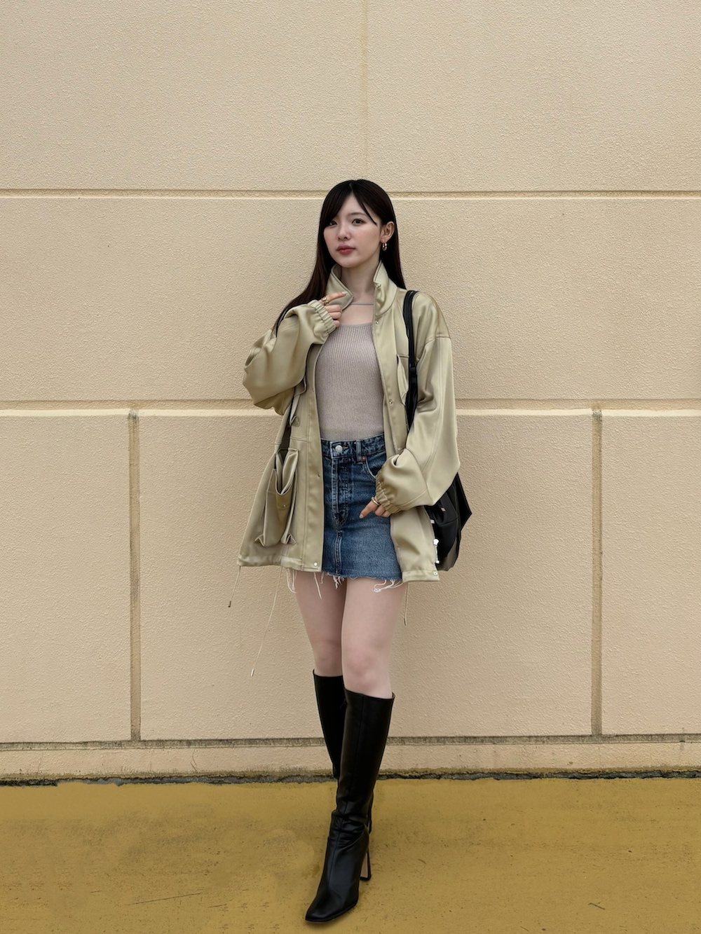 ブルー系のデニムスカート、ブラック系のブーツ、ベージュ系のTシャツ/カットソーを着用したレディースの冬コーディネートの2枚目の写真