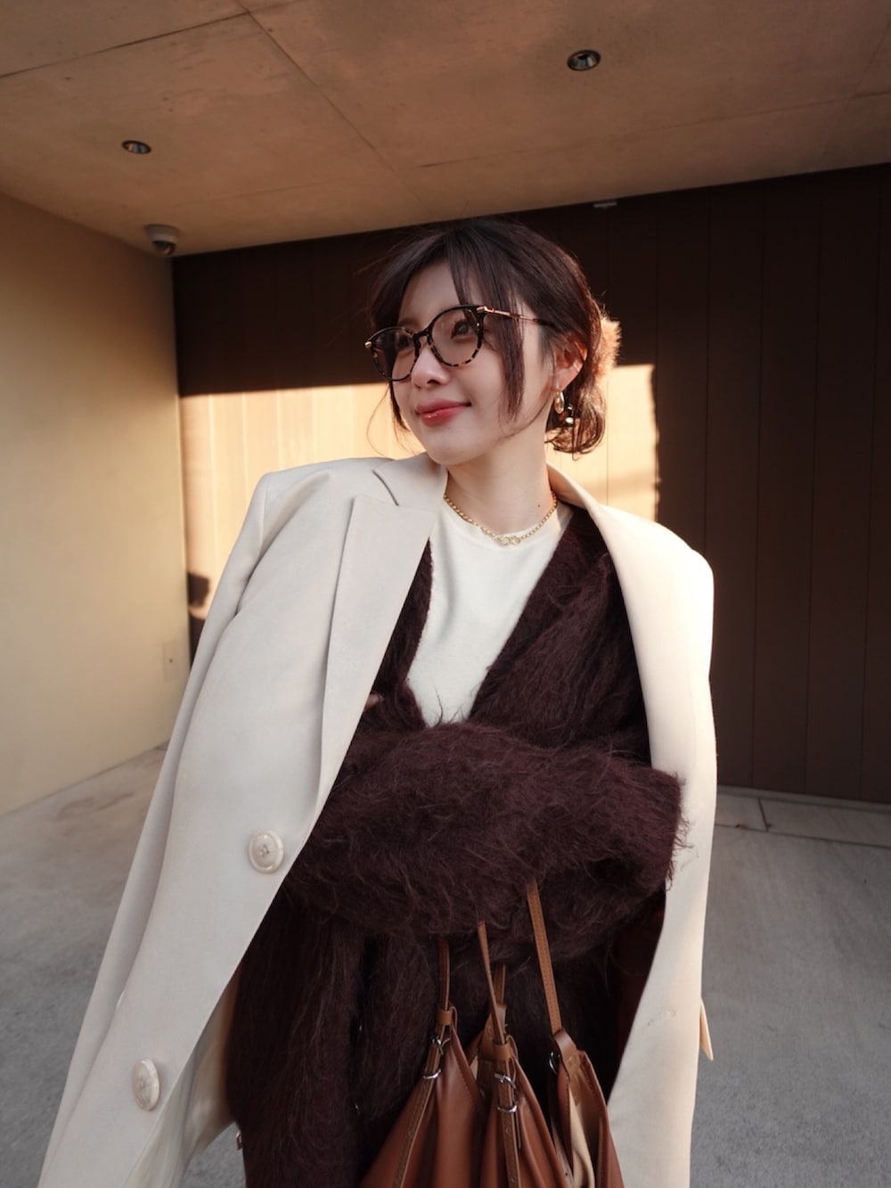 ブラウン系のカーディガン/ボレロ、ベージュ系のテーラードジャケット、ブラウン系のショルダーバッグを着用したレディースの冬コーディネートの4枚目の写真