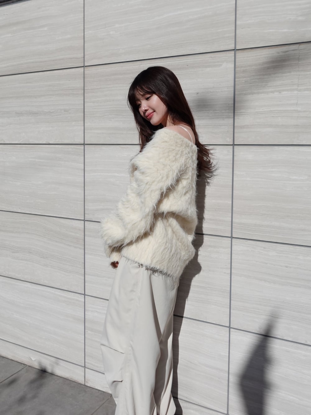 ベージュ系のカーディガン/ボレロ、ホワイト系のカーゴパンツを着用したレディースの冬コーディネートの4枚目の写真