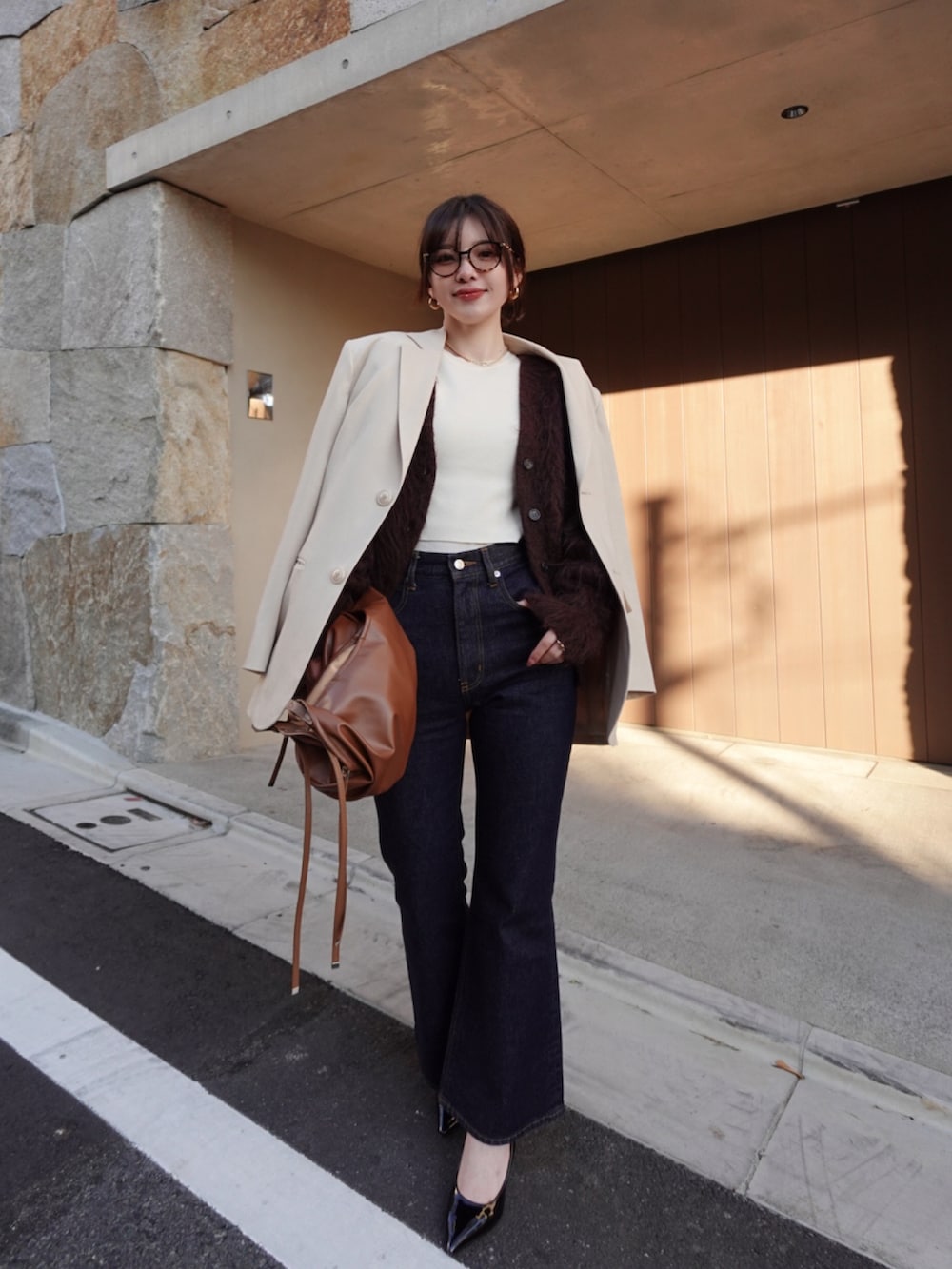 ブラウン系のカーディガン/ボレロ、ベージュ系のテーラードジャケット、ブラウン系のショルダーバッグを着用したレディースの冬コーディネートの2枚目の写真