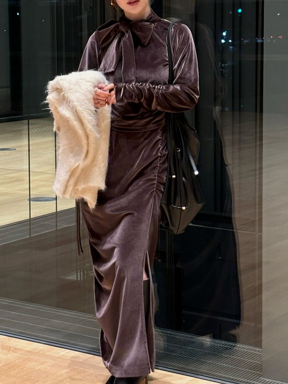 ブラウン系のTシャツ/カットソー、ベージュ系のカーディガン/ボレロ、ブラウン系のスカートを着用したレディースの冬コーディネートの2枚目の写真