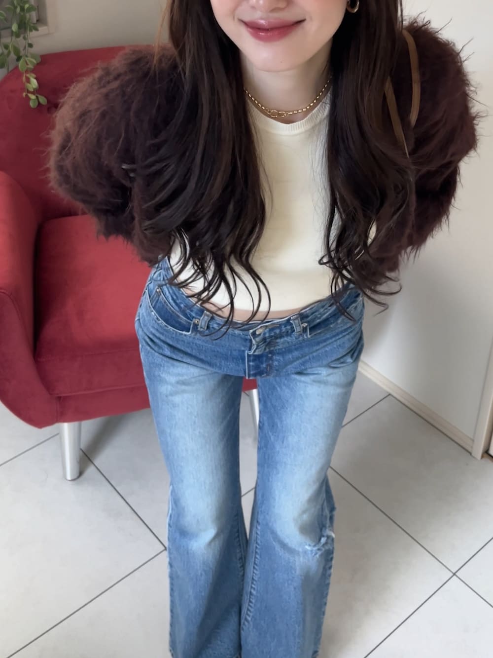 ブラウン系のカーディガン/ボレロ、ホワイト系のTシャツ/カットソー、ブルー系のデニムパンツを着用したレディースの冬コーディネートの2枚目の写真