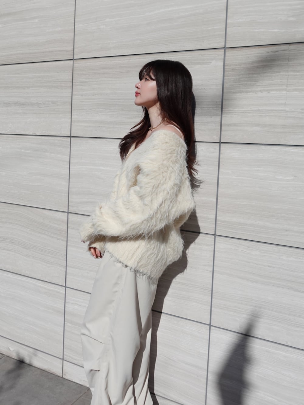 ベージュ系のカーディガン/ボレロ、ホワイト系のカーゴパンツを着用したレディースの冬コーディネートの5枚目の写真