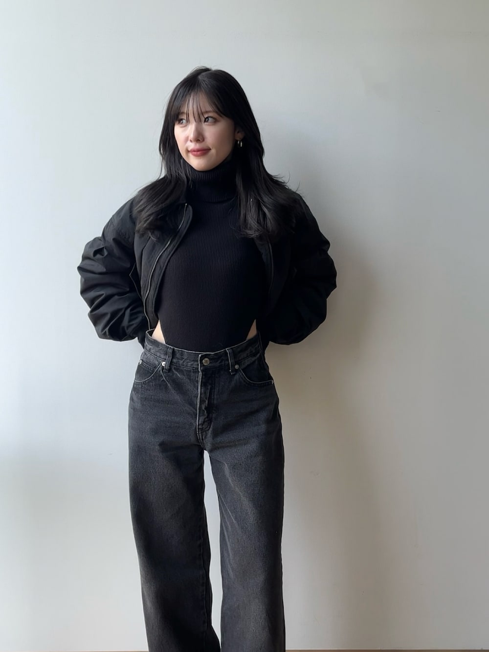 ブラック系のニット/セーター、ブラック系のブルゾン、ブラック系のデニムパンツを着用したレディースの冬コーディネートの3枚目の写真